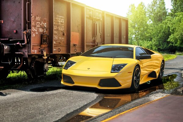 Gelber Lamborghini auf dem Hintergrund eines Güterwagons