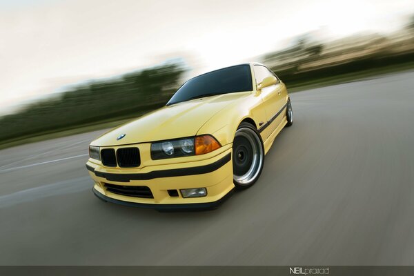 Żółte BMW E36 coupe w ruchu