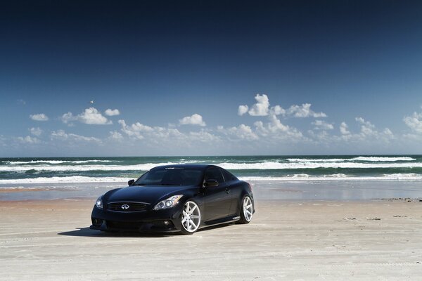 Der schwarze Infiniti steht am Strand