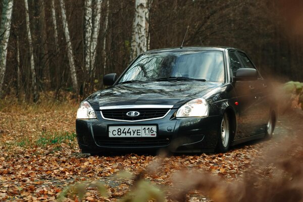 Automne, beaucoup de feuilles. Voiture automatique Lada Priora