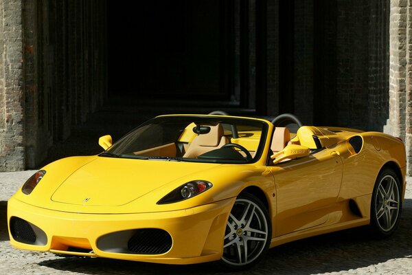 Ferrari amarillo en un camino de ladrillos