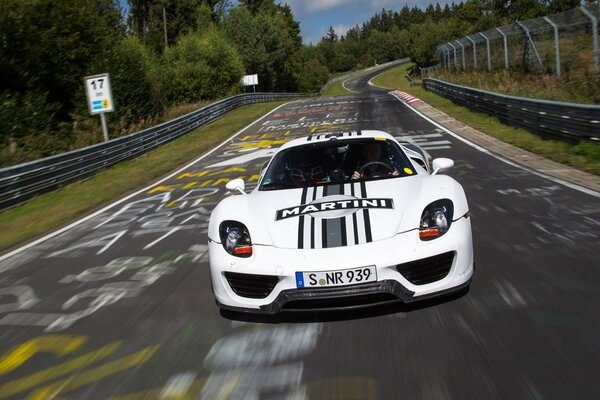 L auto di tuning bianca corre lungo la strada