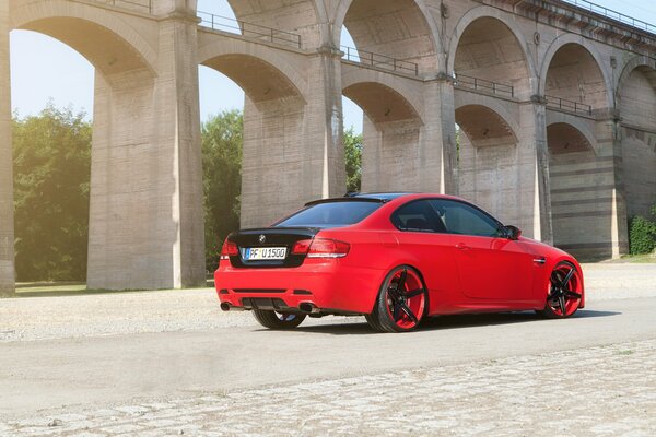 BMW rojo con afinación entre los arcos