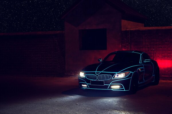 Bmw Z4 negro con luces azules y faros encendidos en la noche