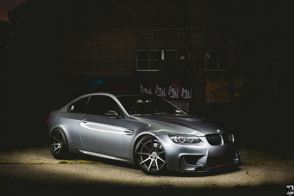 Grauer BMW. Foto der Maschine in der Nacht auf dem Hintergrund des Gebäudes