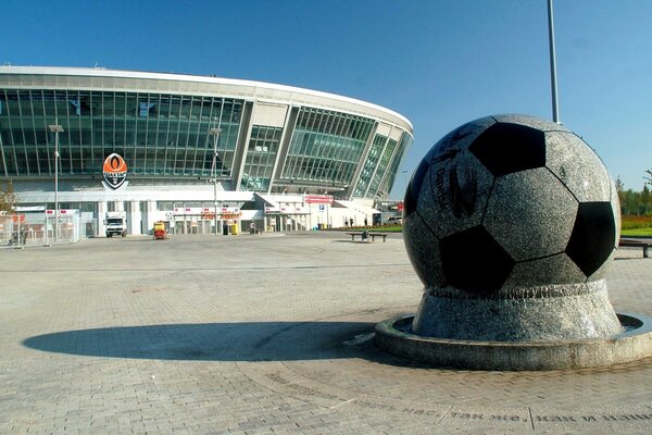 Denkmal für den Ball vor dem Hintergrund des Stadions