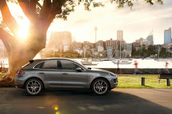 Porsche Macan S argentata parcheggiata sul lungomare sullo sfondo dei grattacieli