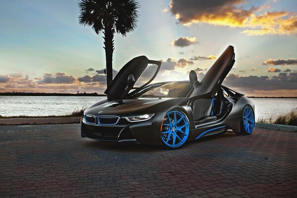 BMW i8 noir sur fond de coucher de soleil, tuning, roues bleues