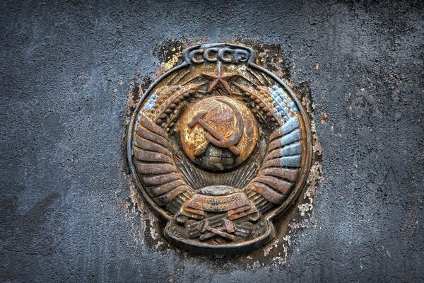 Rusty coat of arms of the USSR with hammer and sickle