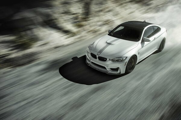 Un bmw M4 blanco viaja a gran velocidad en la carretera