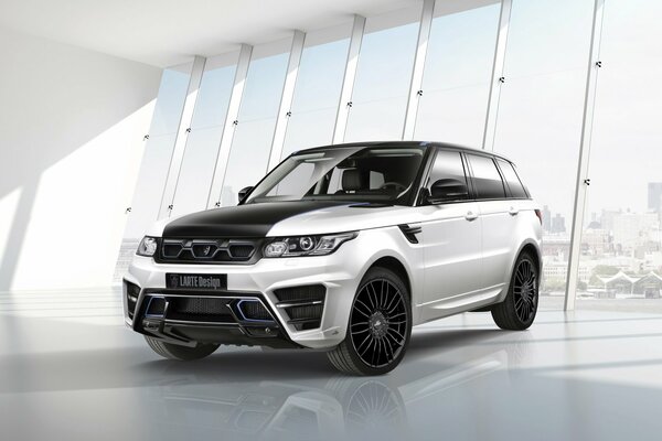 Silver Range Rover larte against the background of the huge windows of the convoy