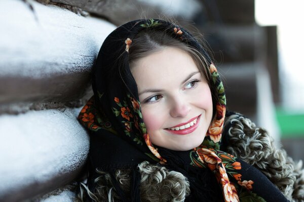 Beauté russe dans un foulard souriant près de la cabane