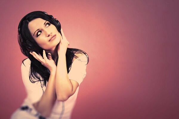 A girl in black headphones listens to music