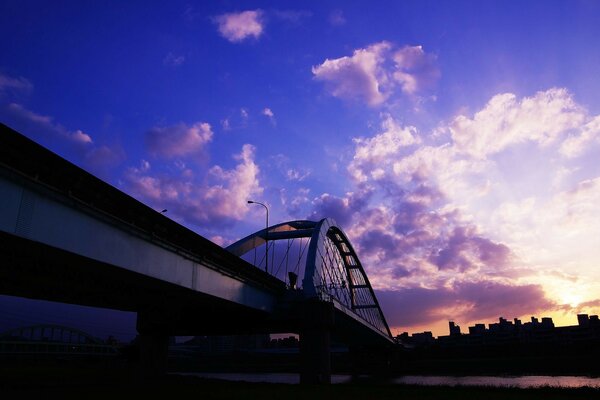 Most w mieście nad rzeką o zachodzie słońca