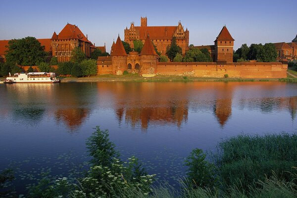 Geheimnisvolle Reflexion von Bäumen und Burg im Wasser