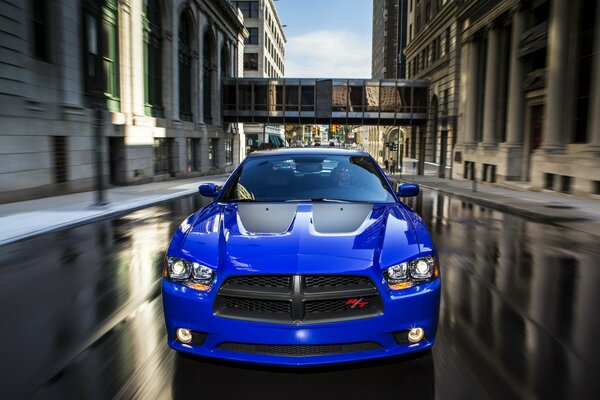 Blue sports car on a wet road in the city