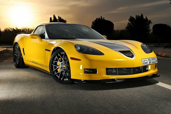 Chevrolet Corvette jaune grand sport sur fond de coucher de soleil