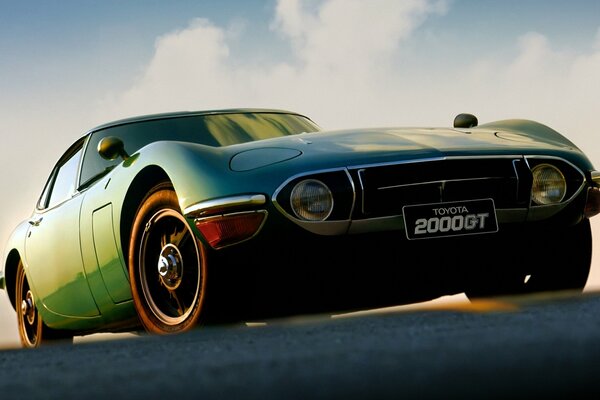 Green Toyota 2000gt at an angle against the sky