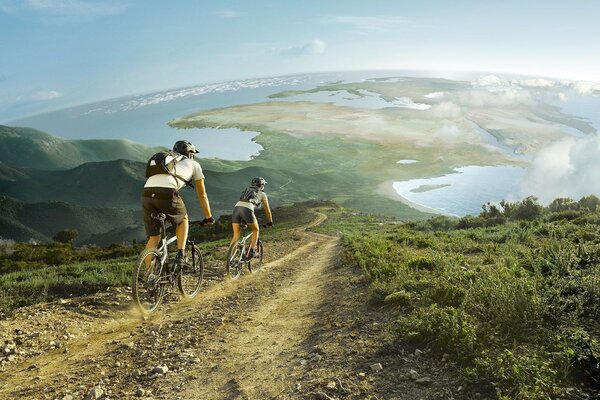 Para jeździ na rowerach wzdłuż zielonych pól