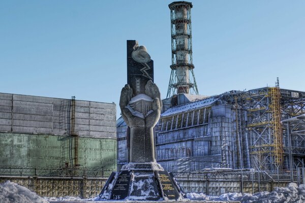 Monument sur fond de sarcophage au-dessus de la centrale nucléaire de Tchernobyl dans la zone dangereuse