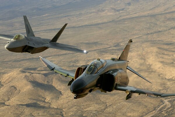 Two military planes fly over the desert