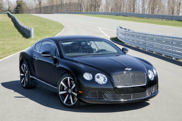 A black Bentley parked on a side branch of the highway