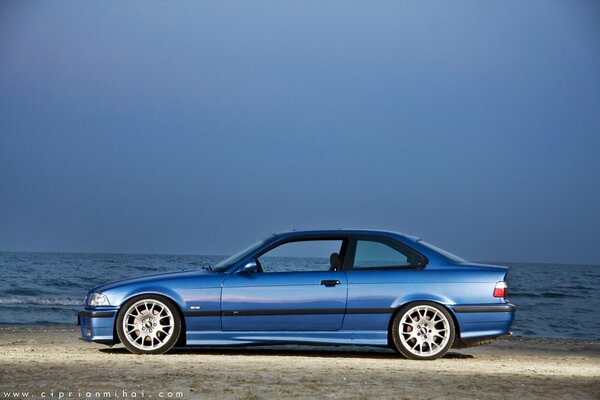 Sports car of the color of the sea on the coast