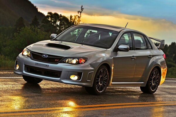 Subaru Impreza grigia in movimento su una pista bagnata