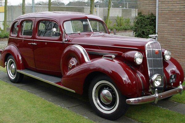 Coche retro rojo cerca de una casa privada