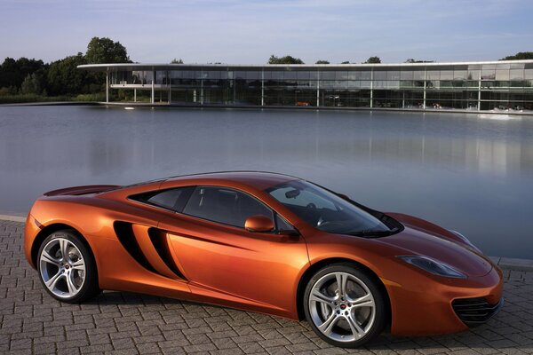 Arancione Sportscar McLaren mp4-12scon lo sfondo della piscina