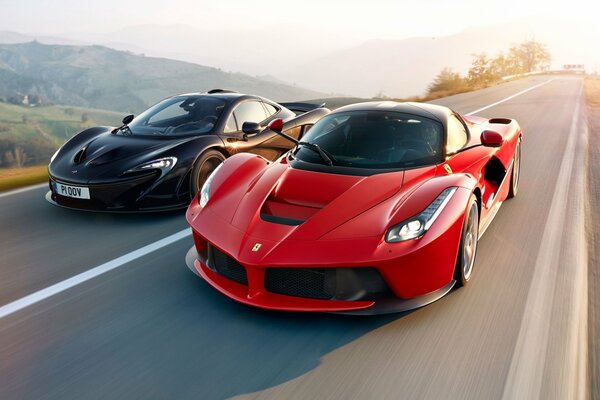 Two cars, a black McLaren and a red Ferrari are driving on the highway