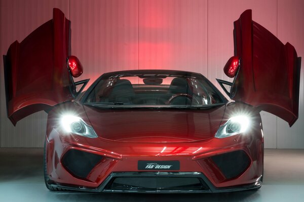 La McLaren MP4-12C rossa sta con i fari accesi e le porte aperte