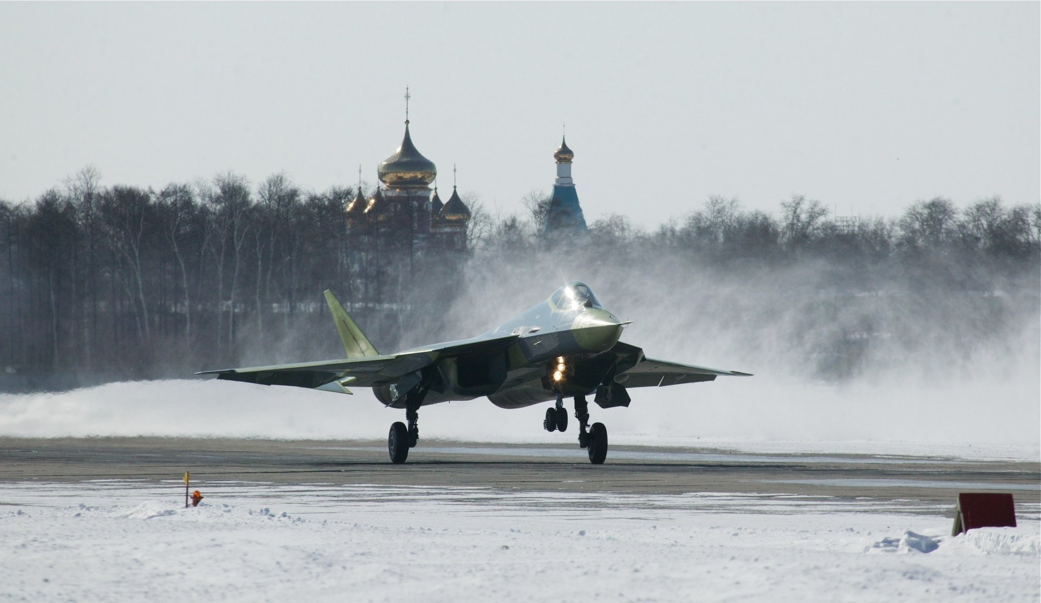 myśliwiec t-50 samolot siły powietrzne federacji rosyjskiej suchy avia kościół świątynia kopuły drzewa śnieg zima lotnictwo wojskowe sprzęt wojskowy lotnictwo religia