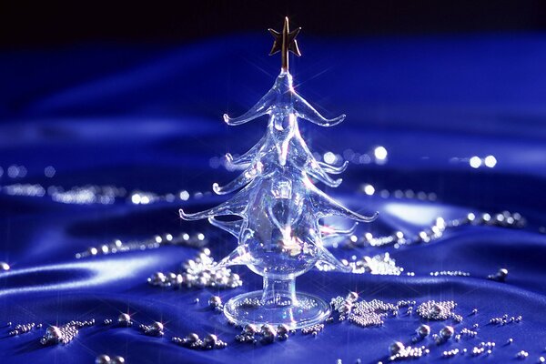 Glass Christmas tree on blue fabric