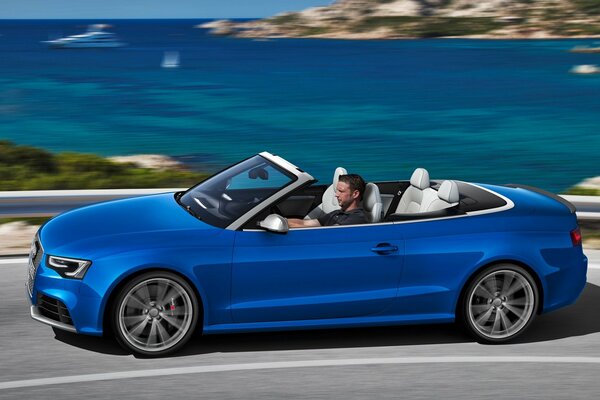 An Audi car in which a man is sitting and trying to go somewhere against the background of the sea