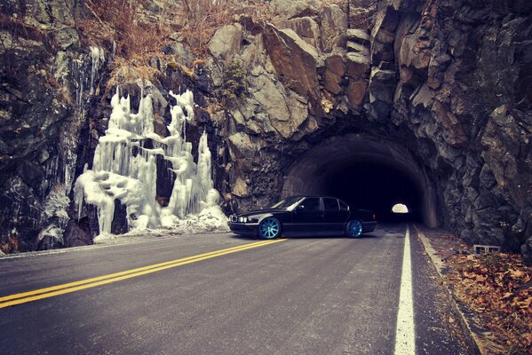 BMW e38 on the road against the background of the tunnel