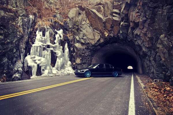 BMW E38 sulla strada sullo sfondo del tunnel