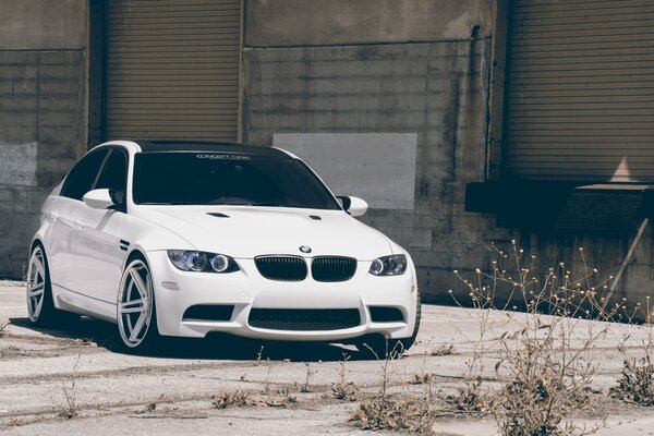 BMW blanco stomt en el estacionamiento al lado del edificio