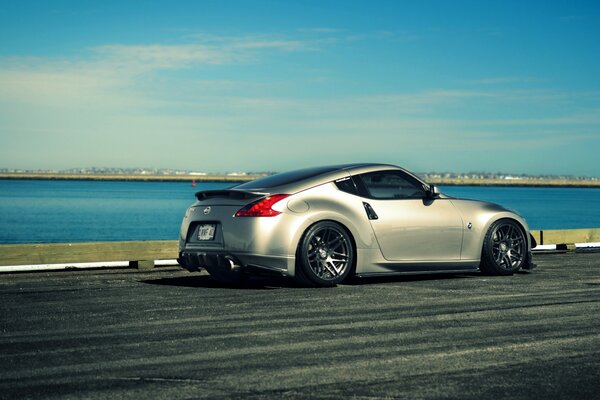 Silver Nissan 370z moving along the river