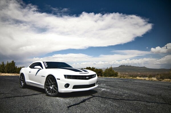 Chevrolet blanco contra las montañas y las nubes