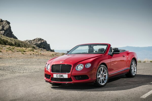 Картинка. Красный автомобиль bentley 2013 года на фоне гор