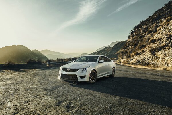 Cadillac coupe in white on the background of mountain ranges