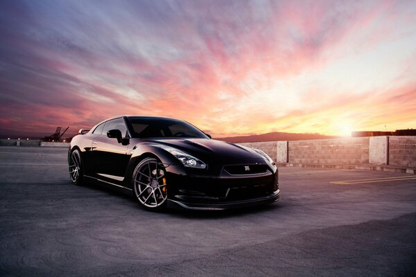 Nissan Black Car sullo sfondo di un bel tramonto