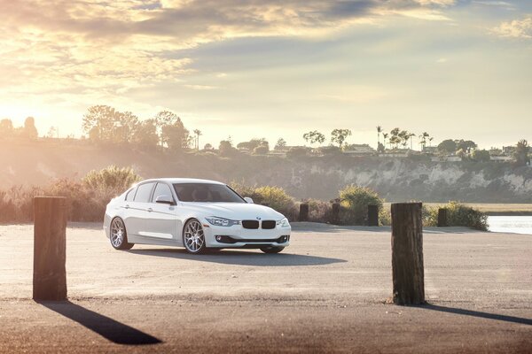 Weiße BMW Limousine auf Sonnenuntergang Hintergrund