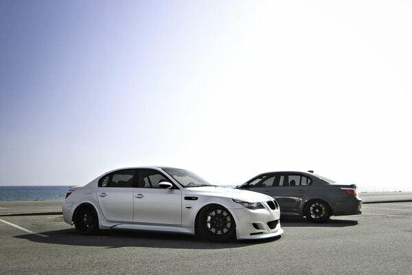 Deux bmw M5 e60 dans un parking en bord de mer