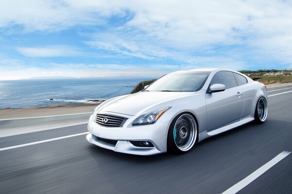 Blanc Infiniti coupé se déplace sur la route