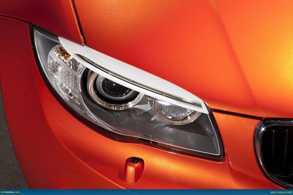 Headlight of an orange bmw 1m sports car close-up