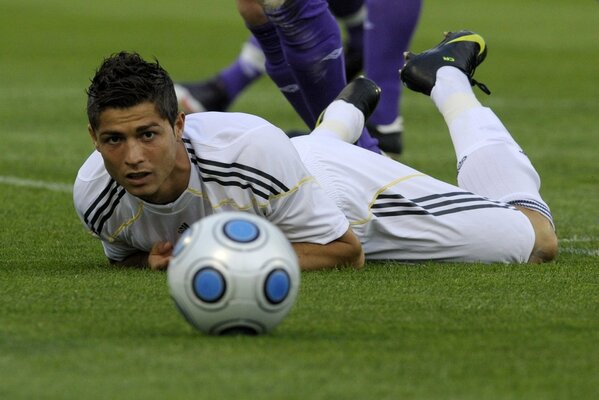 A football game. Ronaldo is lying on the lawn