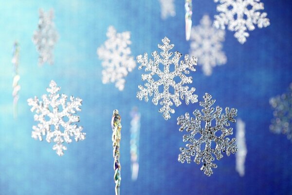Los copos de nieve de año nuevo caen sobre un fondo azul