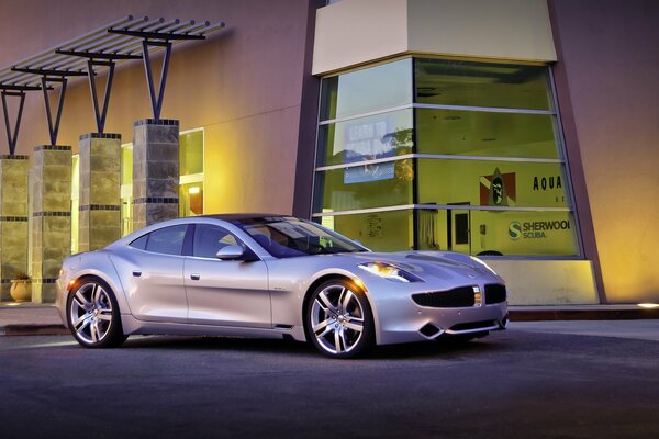 A silver car near a tall building